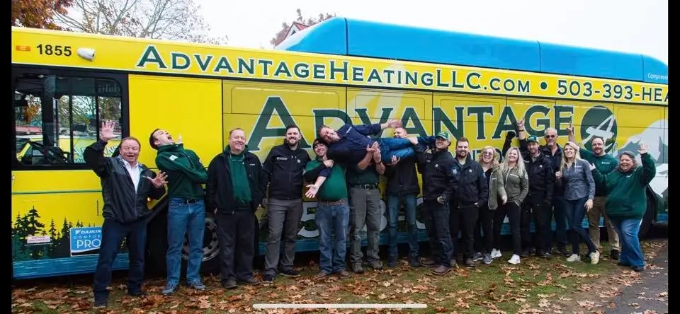 Advantage staff next to bus with logo and advertisement